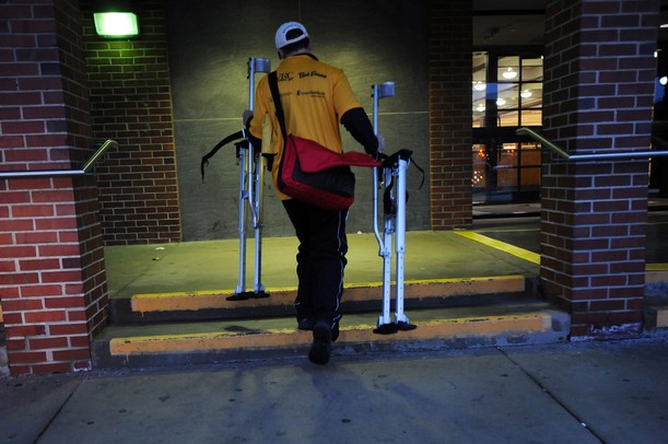 Neil Sauter, 29, of Blissfield, carries his stilts up a couple steps outside of the Ann Arbor District Library in downtown Ann Arbor on Friday, April 12, 2013. Sauter, known as the "Michigan Stiltwalker," is taking a three-day-long walk on the stilts to Lansing as a fundraiser for cerebral palsy. Melanie Maxwell I AnnArbor.com